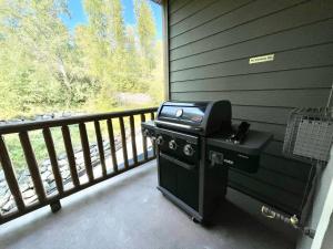 a grill on a screened in porch with a window at 2 Bed 2 Bath with Fire Place in Fernie