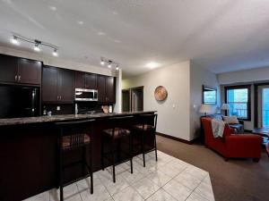 a kitchen with a bar and a living room at 2 Bed 2 Bath with Fire Place in Fernie