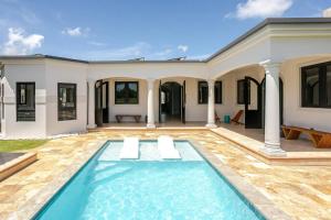 a house with a swimming pool in front of it at Spacious House with Pool and BBQ in Arenales