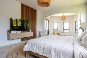a bedroom with a large bed and a flat screen tv at Spacious House with Pool and BBQ in Arenales +74 photos