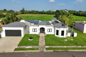 a large white house with solar panels on it at Spacious House with Pool and BBQ in Arenales