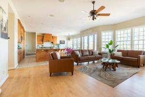 a living room with leather furniture and a ceiling fan at Blue Stone Chateau Yosemite Pool Spa Secluded in Abbeyville
