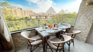 a table on a balcony with a view of the pyramids at Queen Inn Pyramids View in Cairo