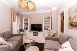 a living room with two couches and a tv at Villa Botanica in Neustadt an der Weinstraße