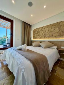 a bedroom with a large white bed with a large window at Apartamentos Finca RiscoTierra in Arafo