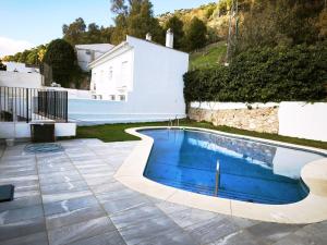 a swimming pool in a yard next to a house at Duplex Apartman with sunny terrace in Mijas Pueblo in Mijas