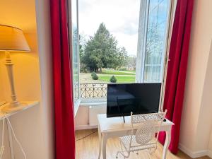 a room with a desk with a computer and a window at Studio au château in Monchy-Humières