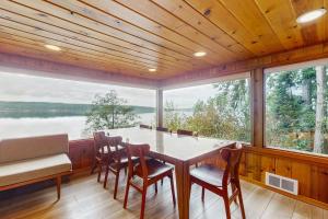 a dining room with a table and chairs and a large window at Eagle Beach Retreat in Freeland