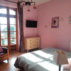 a bedroom with a bed and a flat screen tv at Chambres d'Hôtes Le Loubet in LʼIsle-Jourdain +40 photos