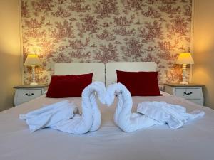 two towels in the shape of swans on a bed at Studio au château in Monchy-Humières