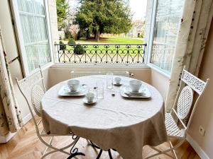 a white table with chairs in a room with a window at Studio au château in Monchy-Humières