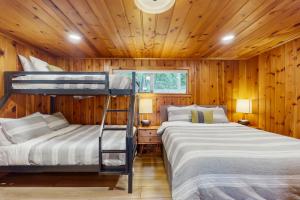 two bunk beds in a room with wooden walls at Eagle Beach Retreat in Freeland