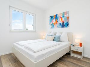 a white bedroom with a large white bed and a window at Casa Del Mar in Stara Novalja