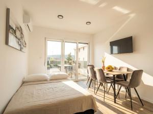 a bedroom with a bed and a table with chairs at Casa Del Mar in Stara Novalja