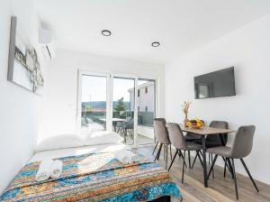a bedroom with a bed and a table with chairs at Casa Del Mar in Stara Novalja +12 photos