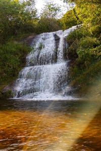 a waterfall on the side of a river at Hotel Caminhos de Itaipava in Itaipava