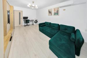ein Wohnzimmer mit einer grünen Couch in einem Zimmer in der Unterkunft The performant in Satu Mare