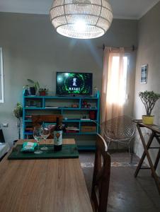 a living room with a table with wine glasses and a television at Kactus de la abuela in Yerba Buena