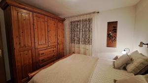 a bedroom with a bed and a large wooden cabinet at APARTMA ANTON in Bled