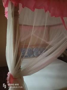 a bed with mosquito netting on top of it at Kizi Villas in Watamu