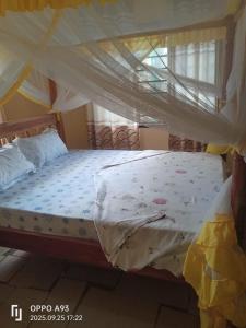 a large bed with a canopy in a bedroom at Kizi Villas in Watamu