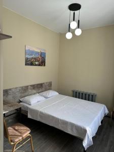 a bedroom with a large white bed and a chair at Assorti in Semey