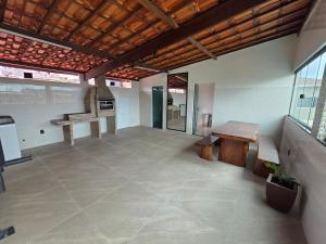 a large room with a table and benches in a building at Inocoop house in Camaçari