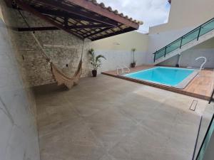 an indoor pool with a hammock in a house at Inocoop house in Camaçari
