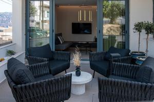 a lobby with chairs and a television and a table at Opulence12 Suites in Karpathos