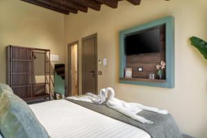 a bedroom with a bed with a tv on the wall at La Piazzetta Sea Rooms in Balestrate