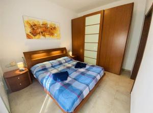 a bedroom with a bed with a blue comforter at Appartamento da Mery in Asso
