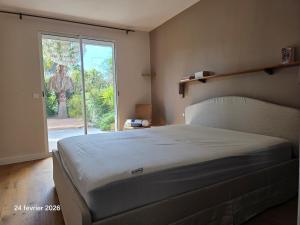 a bedroom with a large bed and a large window at Spacieuse villa au calme avec grande piscine in Bormes-les-Mimosas +55 photos