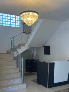a staircase with a chandelier in a building at North Star Hotel in Shkodër