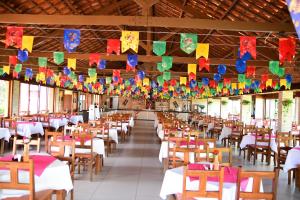 a dining hall with tables and chairs and flags at Hotel Serrano Martins in Martins +50 photos