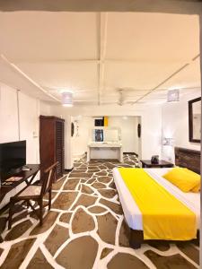 a bedroom with a bed and a table and a desk at Luwa Beach&Suits in Watamu
