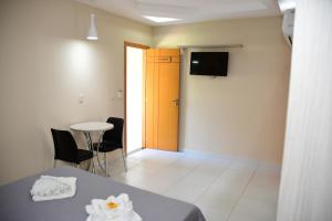 a room with a bed and a table and a television at Hotel Serrano Martins in Martins