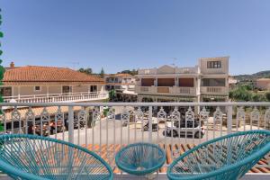 two blue chairs sitting on a balcony with a patio at Maroudas Apartments in Planos