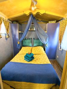 a small bedroom with a bed with a blue comforter at Domaine De JI in Montagnac