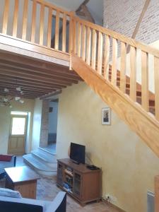 a living room with a staircase and a television at Gaëtan in Lainsecq