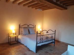 a bedroom with a bed with two lamps on it at Gaëtan in Lainsecq
