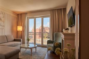 a living room with a couch and a large window at Hotel am Delft in Emden