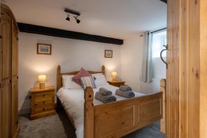 a bedroom with a wooden bed with towels on it at Bryn Lon in Caeʼr-geiliog