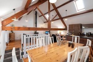a kitchen and dining room with a wooden table and chairs at Bryn Lon in Caeʼr-geiliog +11 photos