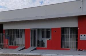 a red building with cats in cages in it at Apartamento próximo ao centro in Primavera do Leste