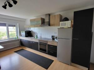 a kitchen with a white refrigerator and a microwave at Ferienwohnung Kraichgaublick in Angelbachtal