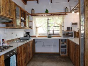 a kitchen with wooden cabinets and a window at Wild Eden Self-Catering Accommodation in Swakopmund +16 photos