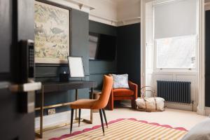 a bedroom with a desk and two orange chairs at 35 Kirkgate in Thirsk
