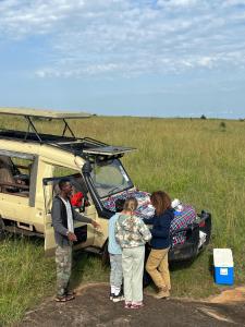 a group of people standing in front of a van at Escape Haven Mara in Masai Mara
