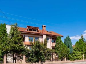 a house with trees in front of it at Garden Hostel in Skopje