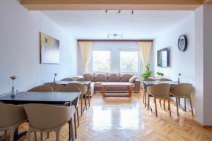 a living room with a couch and tables and chairs at Garden Hostel in Skopje